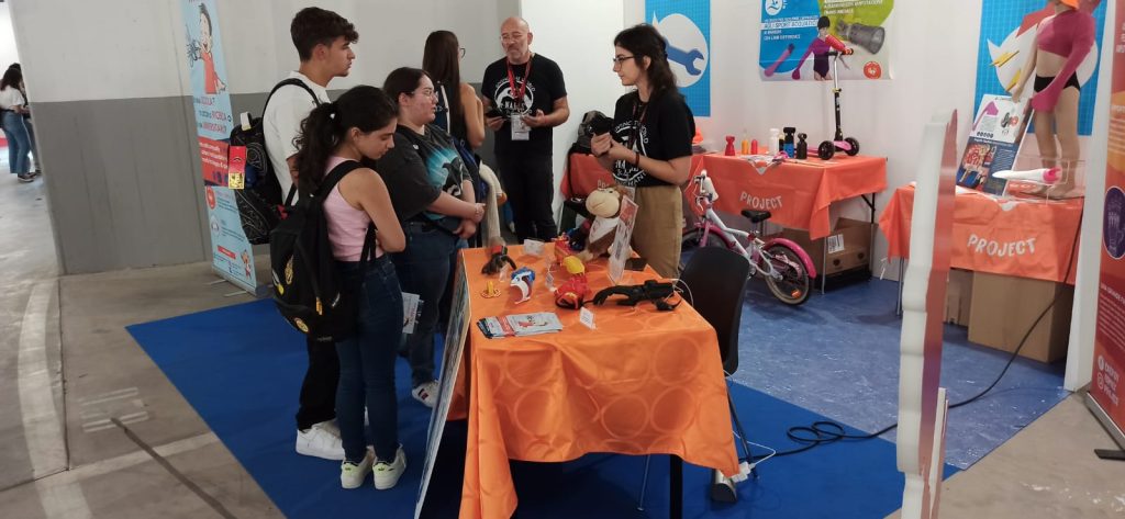 i volontari di e-Nable Italia spiegano il funzionamento del device presentato in fiera